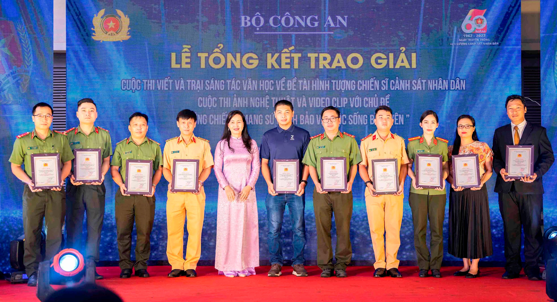 Chủ tịch Hội NSNAVN Trần Thị Thu Đông trao giải A hạng mục Ảnh bộ cho các tác giả đoạt giải.